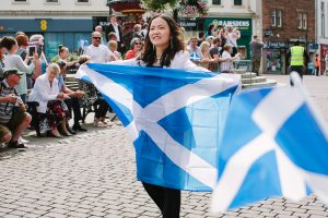 A girl carrying the Scottish flag for Queen's Baton Relay in Dumfries