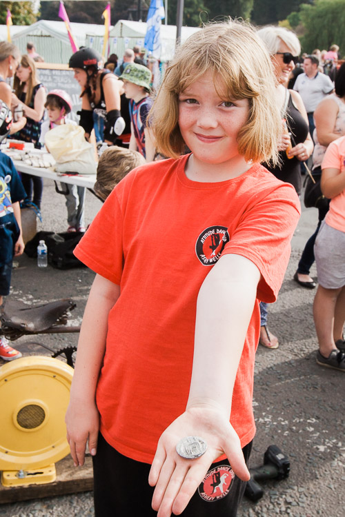 Young boy showing a finished metal button produced during the Nithraid demonstrations