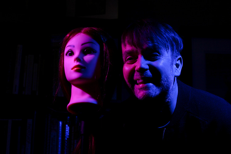 A man and a mannequin lit with coloured gels