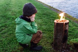 Boy looking at Nordic log fire