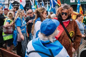 Fancy dress SNP supportes talks to the participant wrapped in St Andrews flag