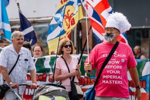 Facing pro-Union supports - a man in a Briitsh colonial helmet wearing "Keep calm and bow before your Imperial masters" T-shirt and a Union Jack