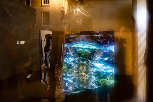Heather Lander's sonic art piece viewed from the street, with Dumfries urban structures reflected in the window