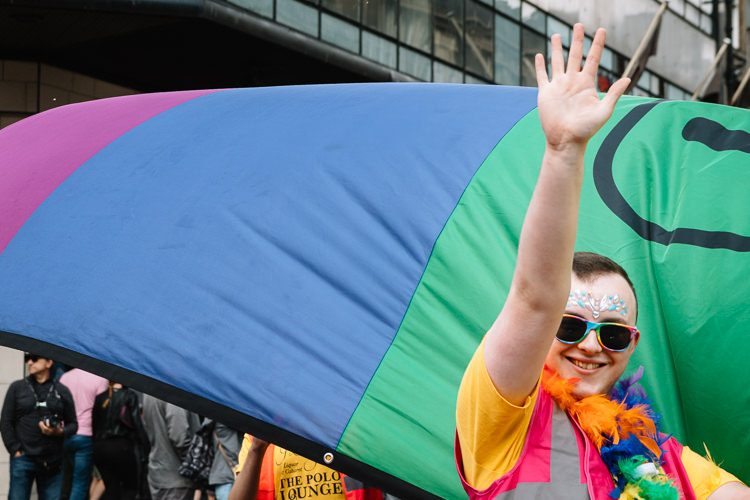 A participant of Glasgow Pride Parade greets Glaswegians lining the streets
