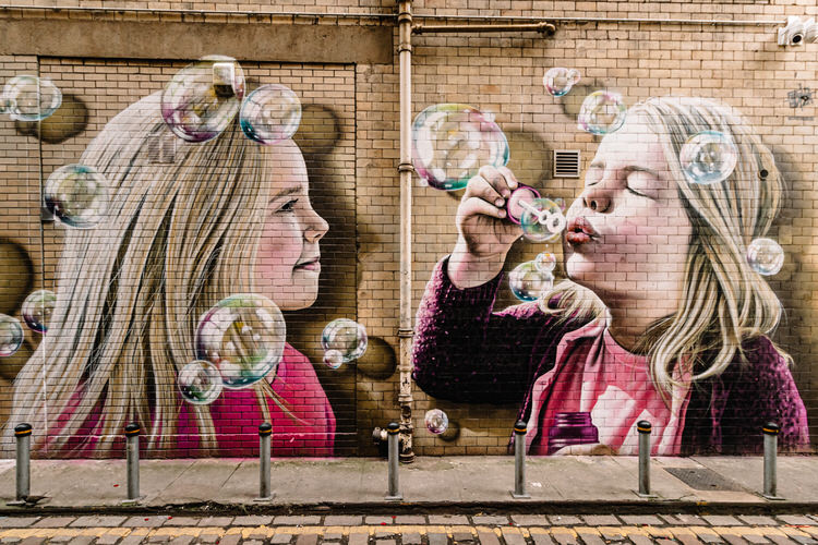 On the wall opposite - two girls having fun with bubbles